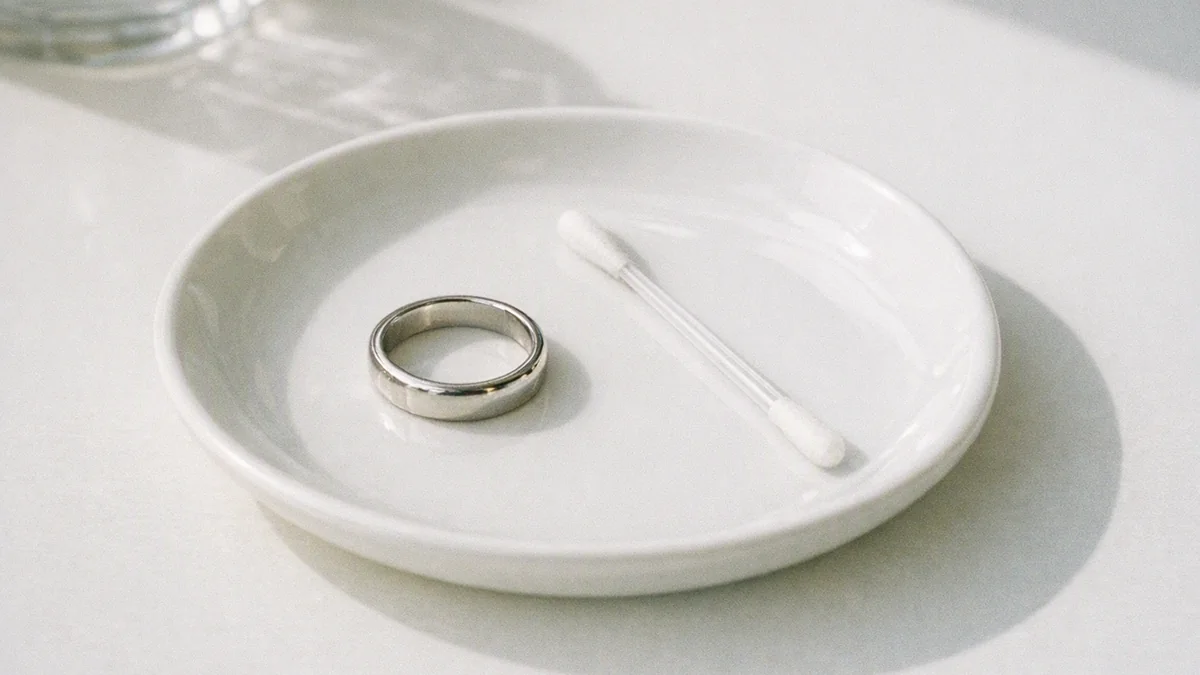 Ring bredvid nickeltestpinne på vitt fat